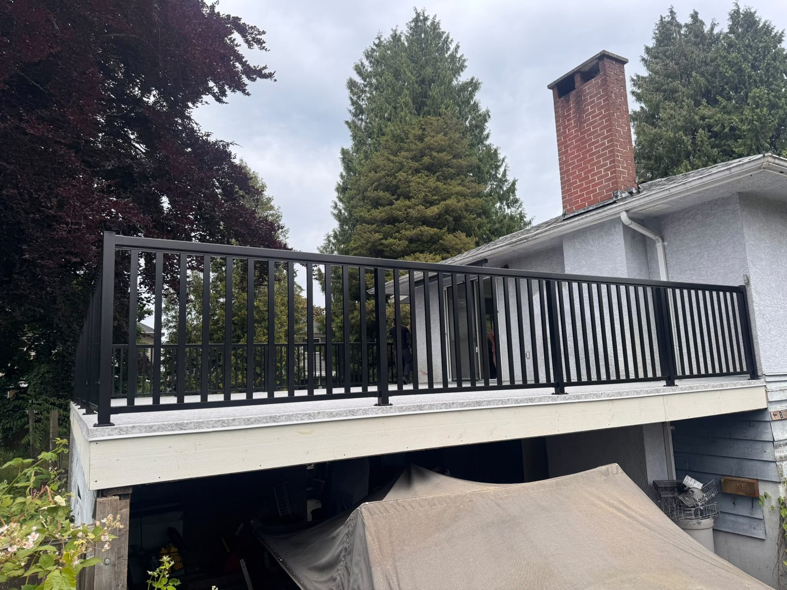 Black aluminum picket railing on a raised deck in Delta