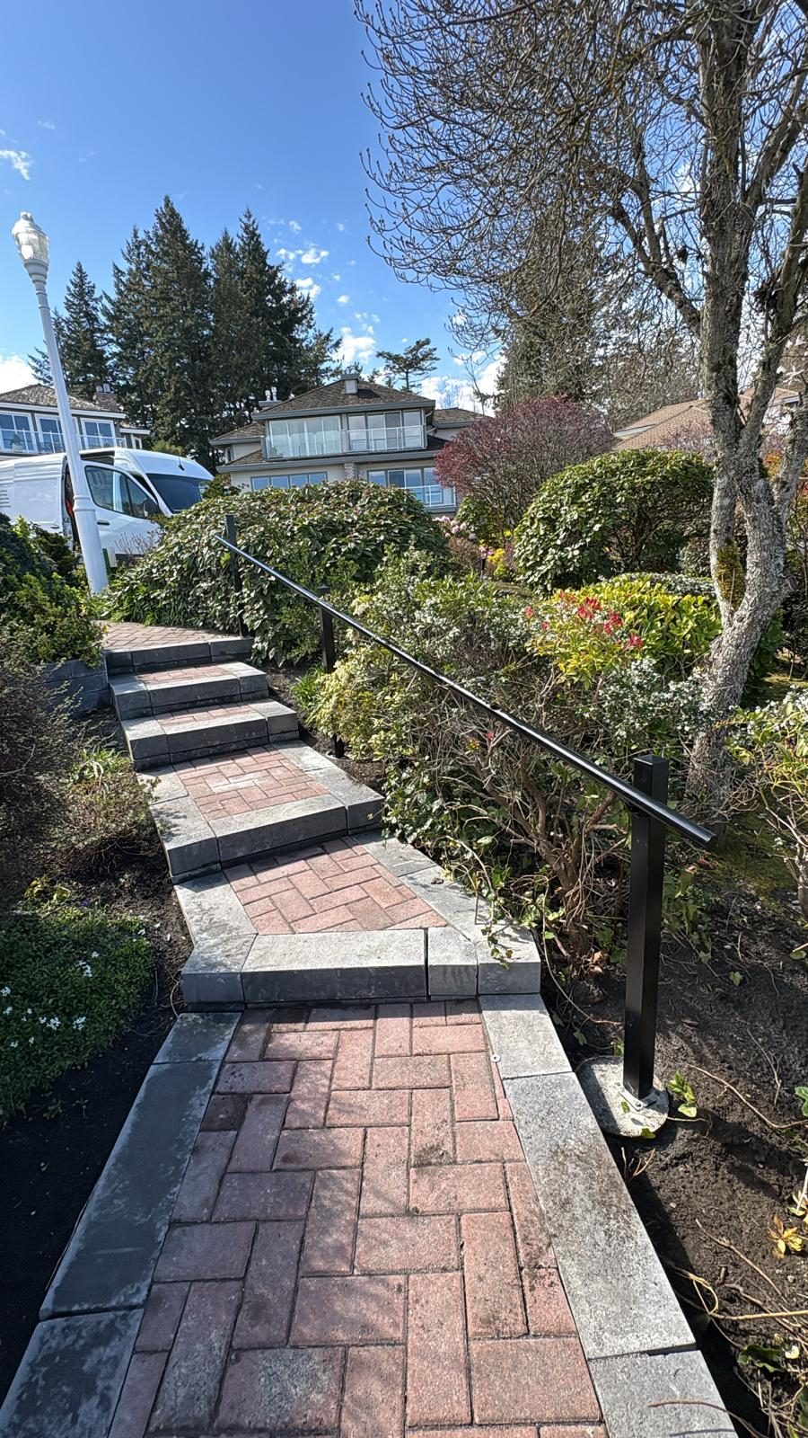 Black aluminum handrail along a garden path in Tsawwassen