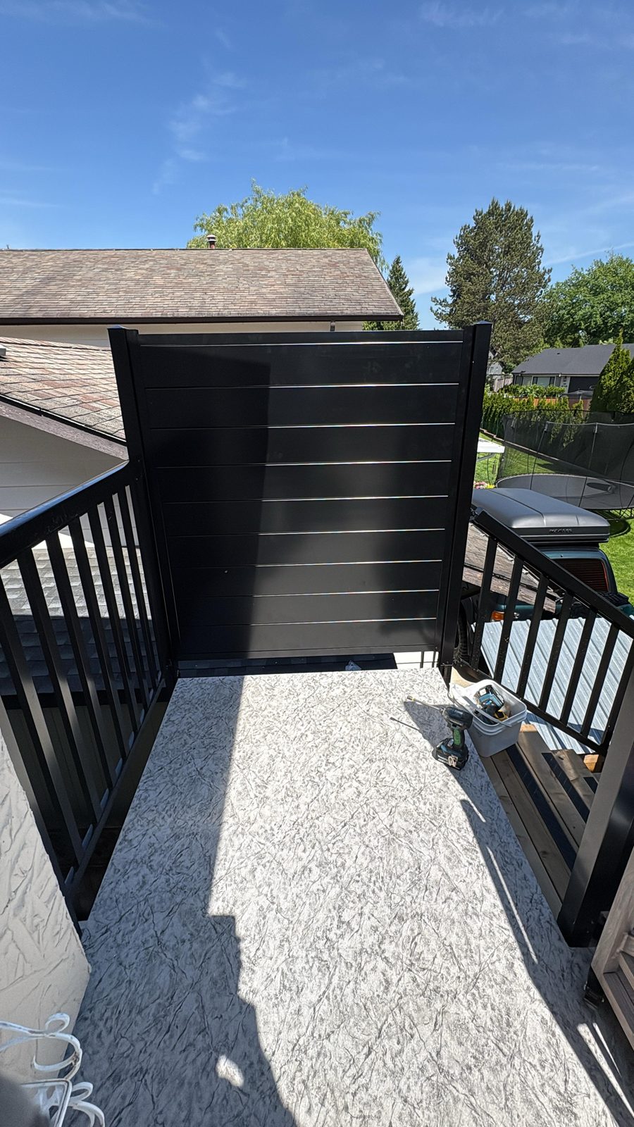Black horizontal aluminum privacy panel installed on a Langley deck
