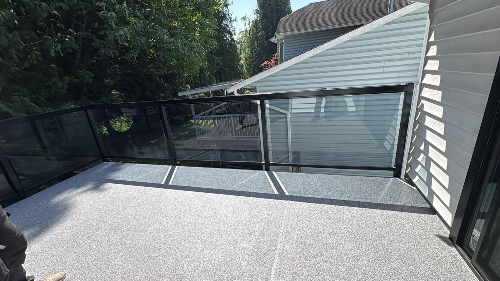 Glass railing with slim aluminum posts on a vinyl deck in Langley