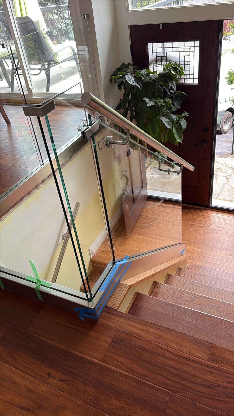 Interior glass stair railing with wood handrail in a North Vancouver home