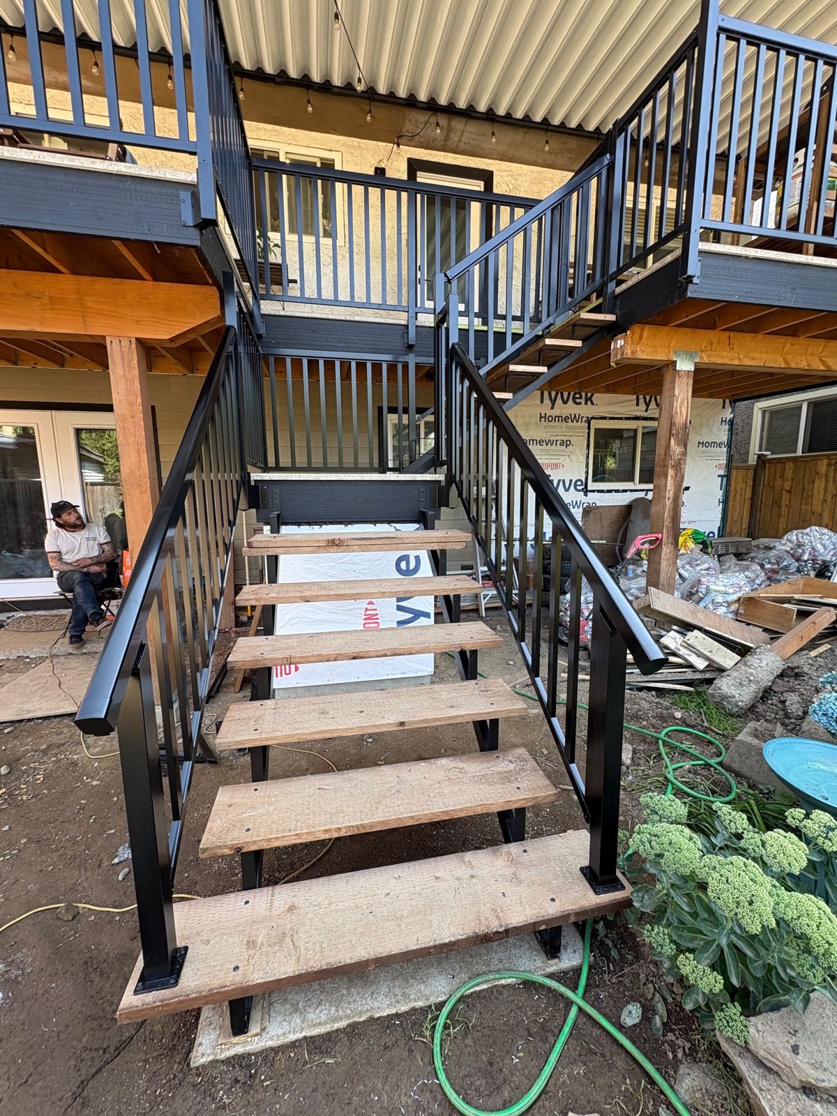 Black aluminum picket stair railing under a covered deck in North Vancouver
