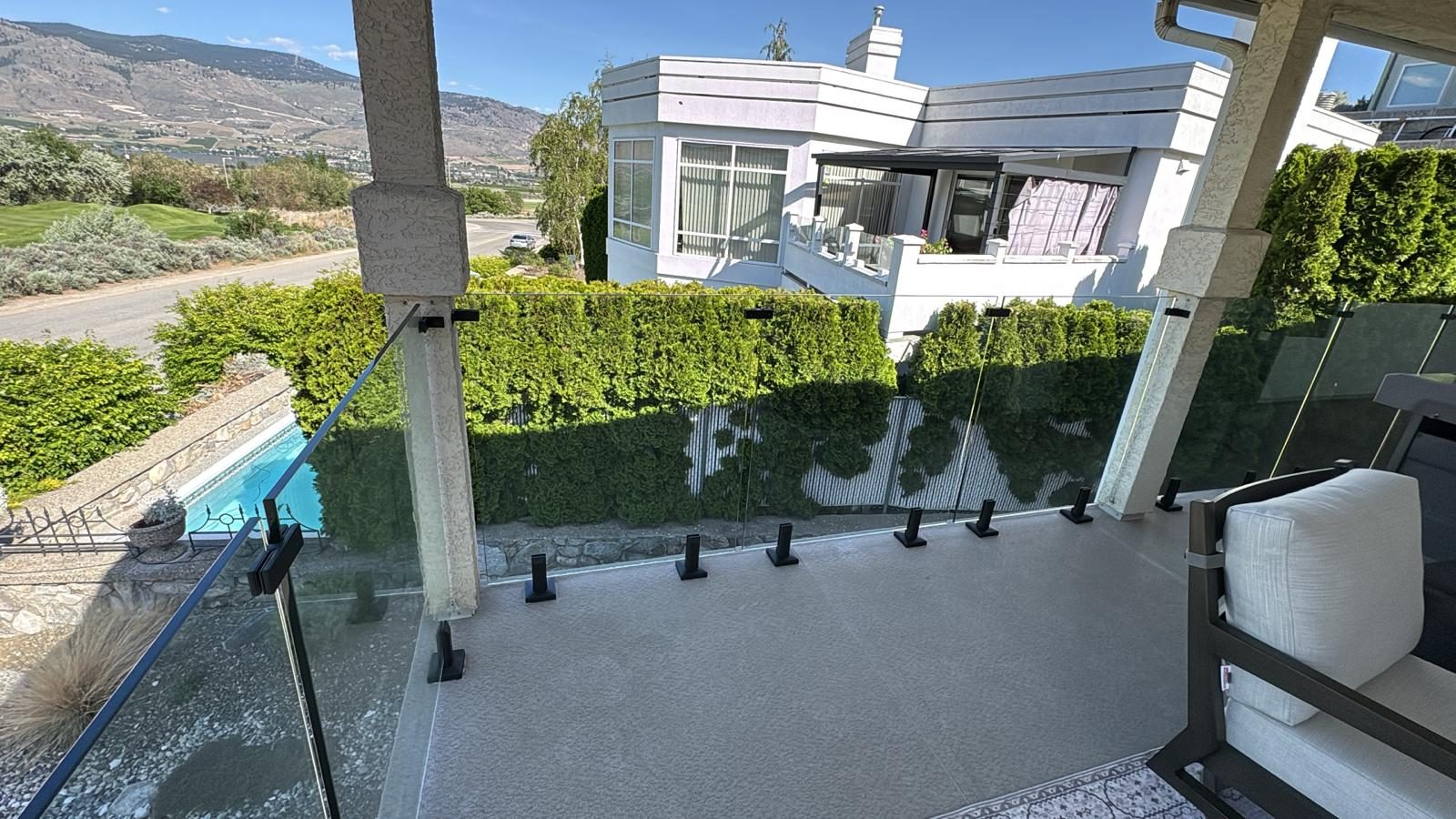 Glass railing on stainless spigots around a patio in Osoyoos