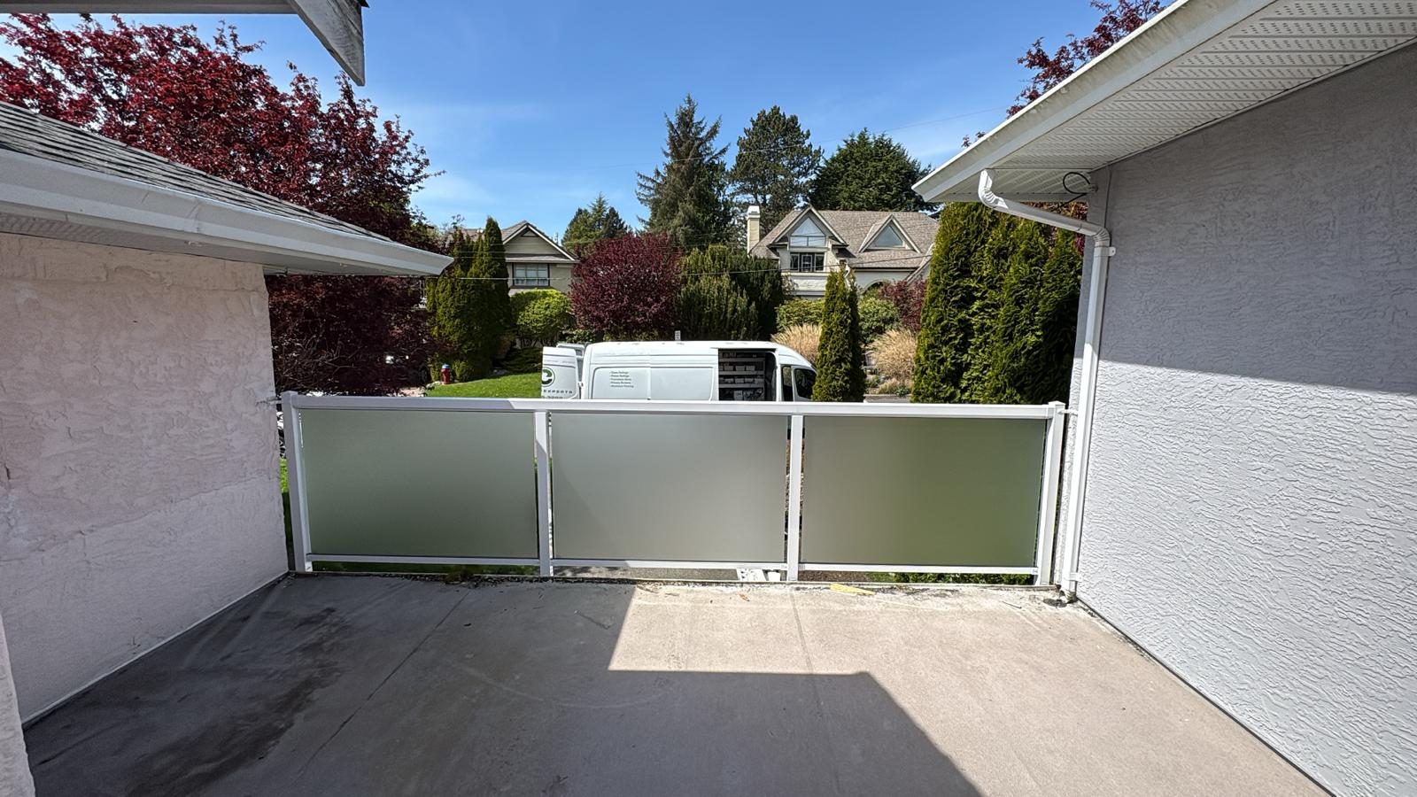 Frosted glass and aluminum gate across a driveway in Victoria