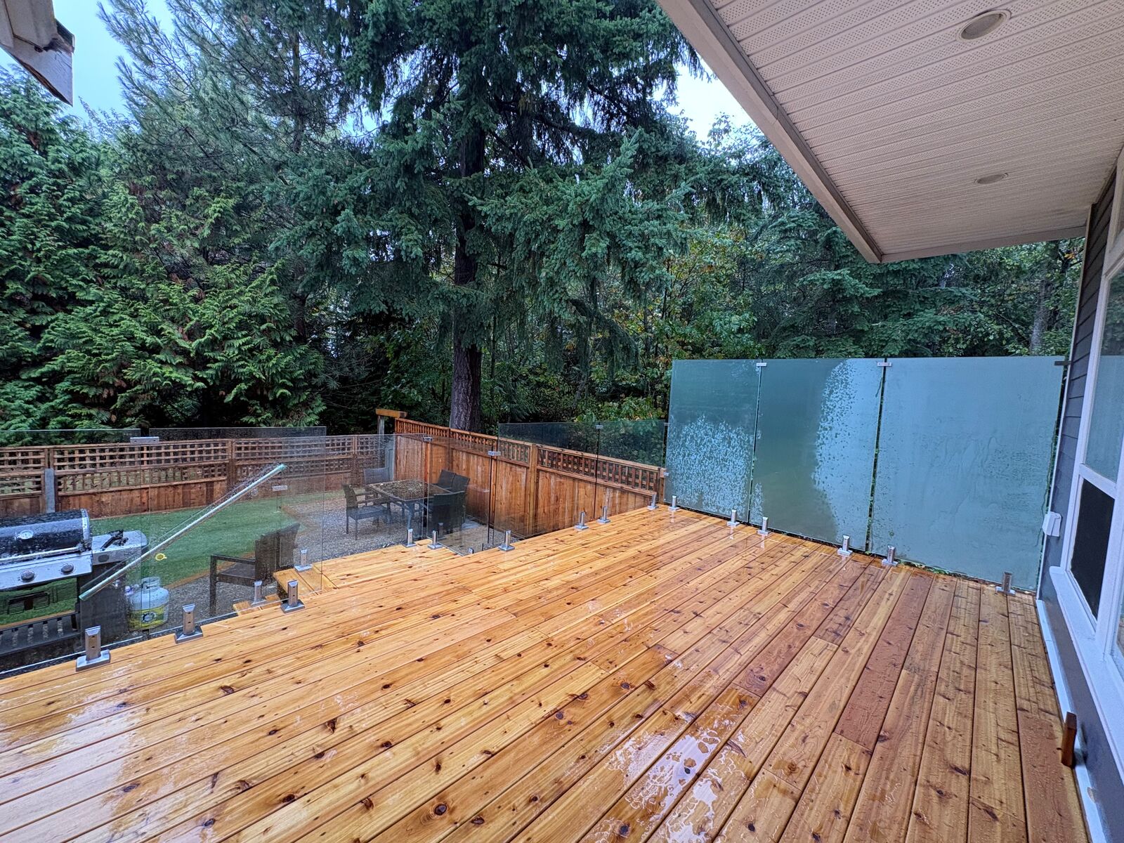 Frosted glass privacy wall and clear glass railing on a cedar deck in South Surrey